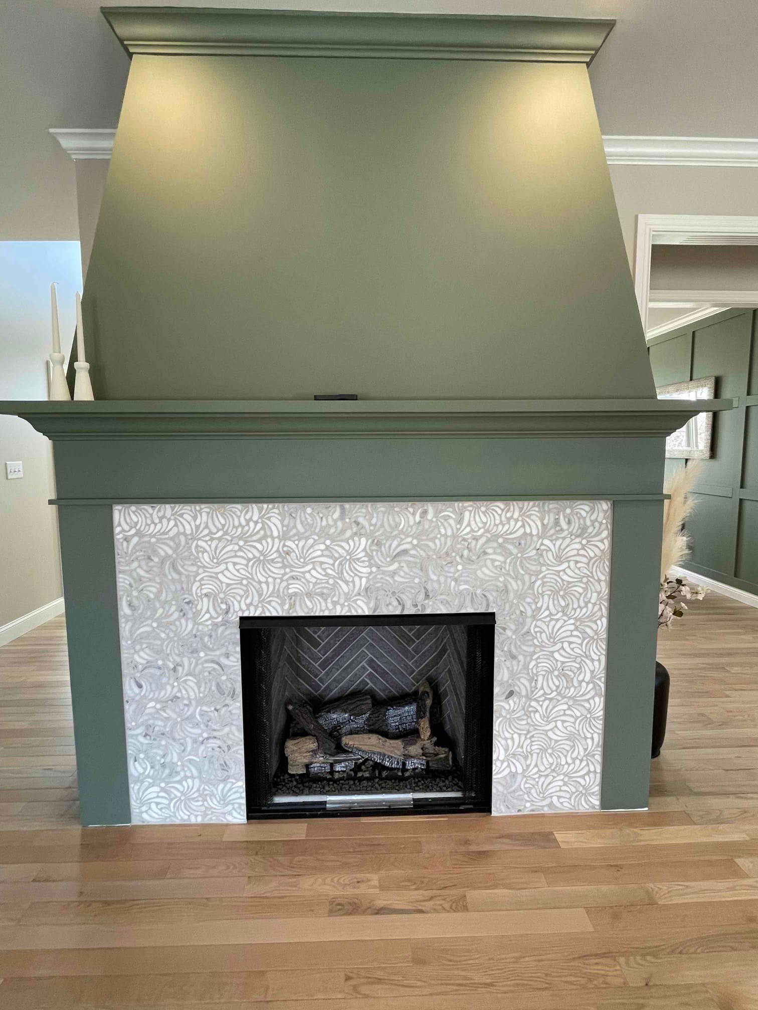 Green painted fireplace surround with a custom mantel and decorative white tile